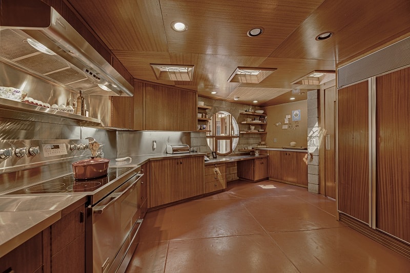 wood-clad kitchen with stove and a small round window