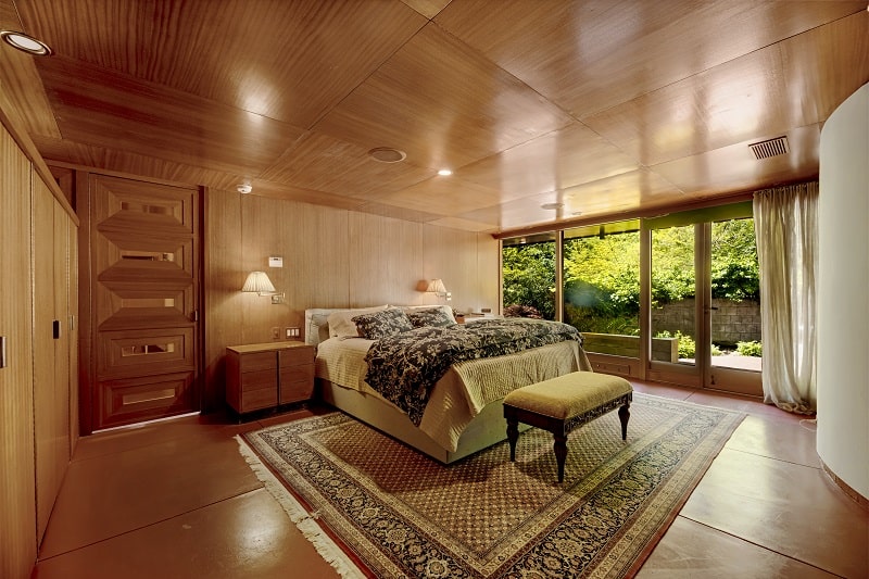 wood-paneled bedroom inside Frank Lloyd Wright's Tirranna house, with a bed in the center