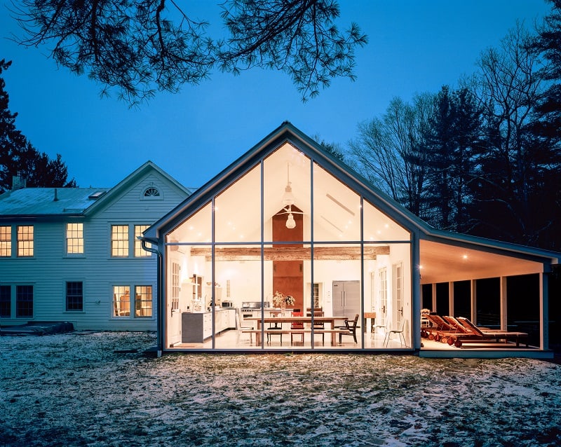 the floating farmhouse seen at night time, with the lights on