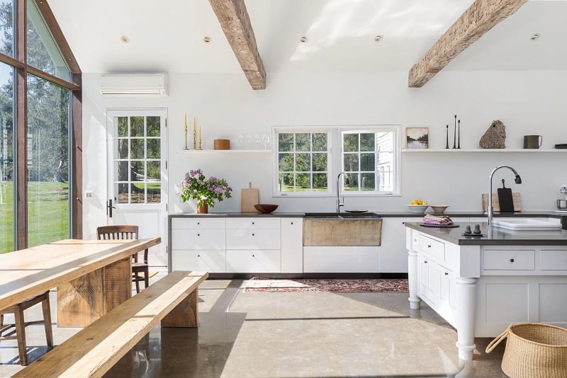 The updated kitchen inside the Floating Farmhouse, sporting white cabinets and dark-colored counters