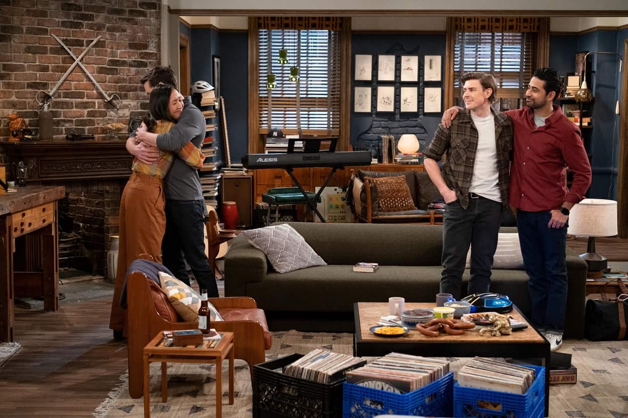 Ellen (Tien Tran) hugging Charlie (Tom Ainsley), with Jesse (Christopher Lowell), and Sid (Suraj Sharma) looking at them lovingly in a scene that takes place inside the How I Met Your Father apartment. 