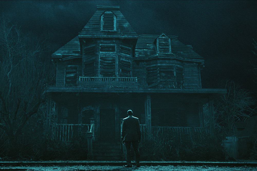 Carl Lumbly as C. Auguste Dupin in episode 101, sitting in front of the dilapidated house in The Fall of the House of Usher.  