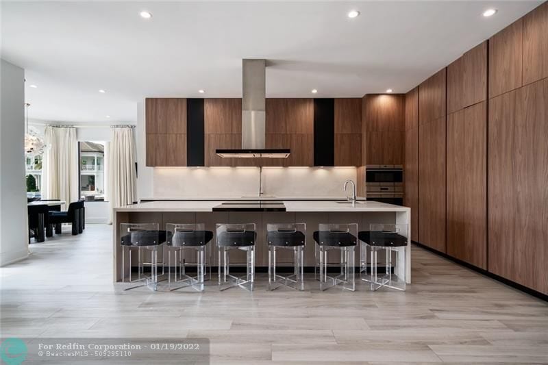 Brown kitchen with an island and counter stools inside Lionel Messi's house in Fort Lauderdale, Florida