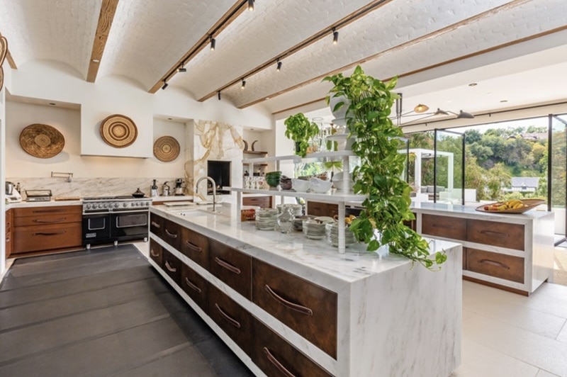 The kitchen features not one, but TWO waterfall-edge marble islands 