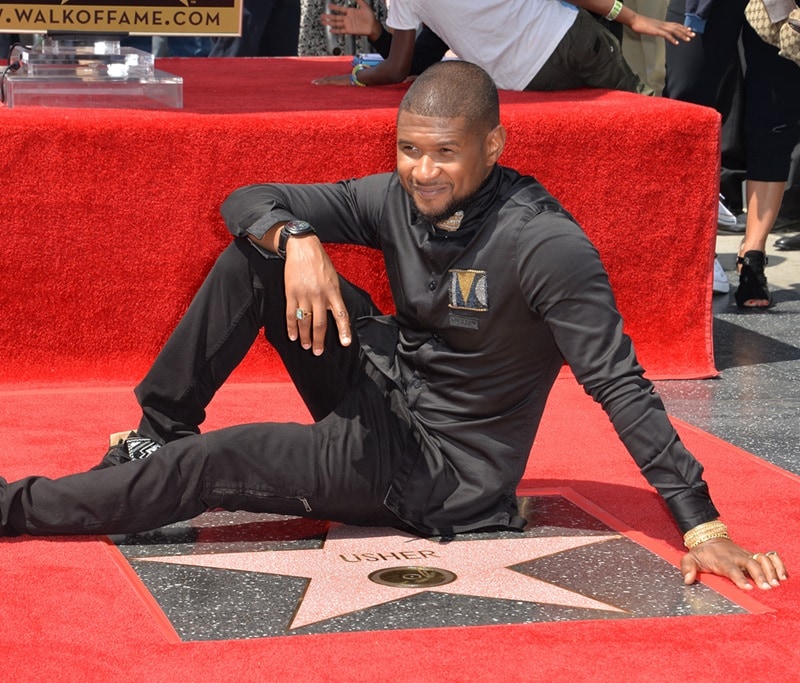 Usher Raymond IV next to his star on the Hollywood Walk of Fame.