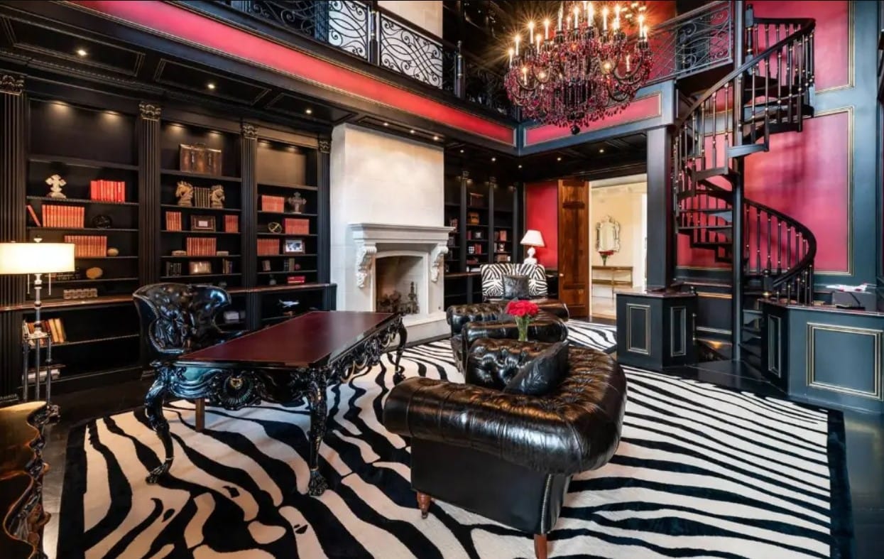 The study matches the opulence we find in the rest of the house but takes it up a notch with its dramatic black, white, and red design. 