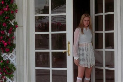 Alicia Silverstone as Cher Horowitz standing at the entrance of her Clueless mansion. Photo credit: IMDB