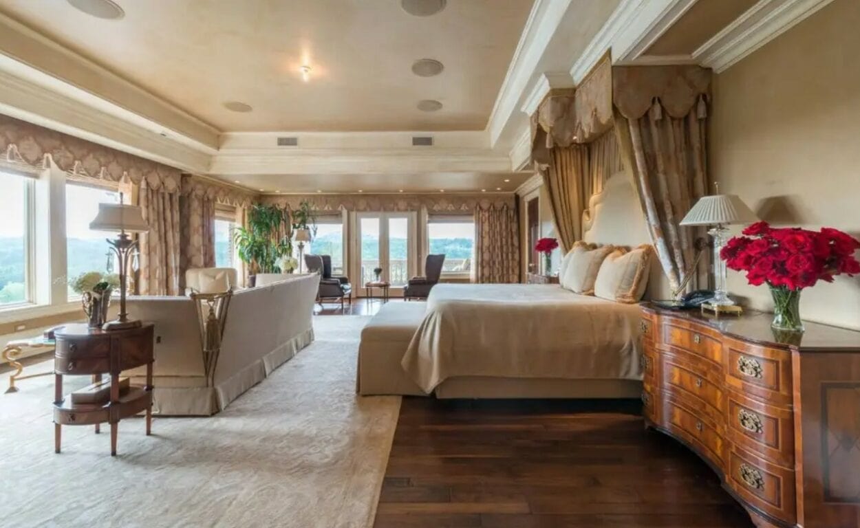 The primary bedroom has extra generous proportions, with large windows overlooking the sprawling grounds of the property.