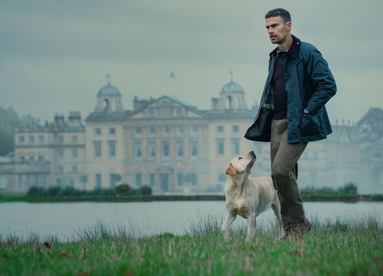 Theo James as Eddie Horniman, walking his dog on the grounds of Halstead Manor, the house in The Gentlemen TV series