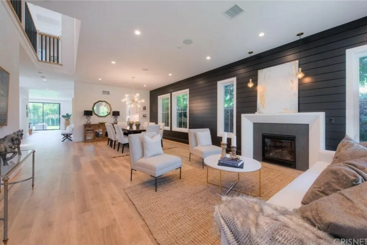 Living room with fireplace, with the dining area behind it inside Tom and Ariana's house on Vanderpump Rules. Photo credit: Realtor.com / Michael Taylor Homes