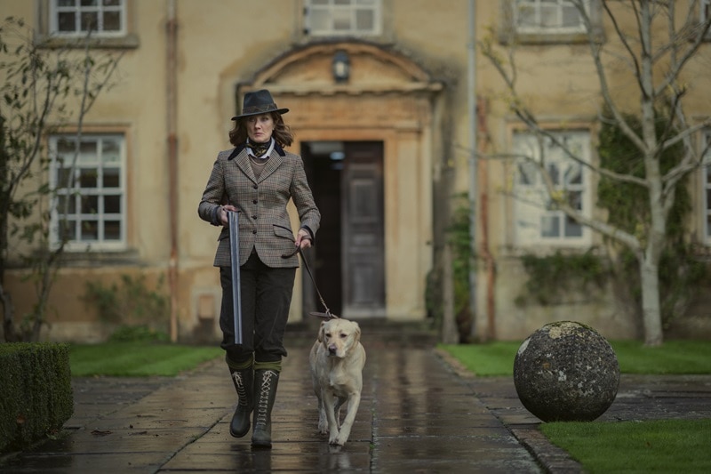 Joely Richardson as Lady Sabrina in The Gentlemen, seen here walking out of Halstead Manor with her dog. Photo credit: Netflix