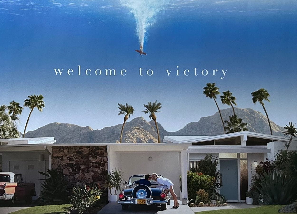 Promotional poster for Don't Worry Darling showing Jack and Alice in front of their house in the idyllic Victory neighborhood. Photo credit: Warner Bros.