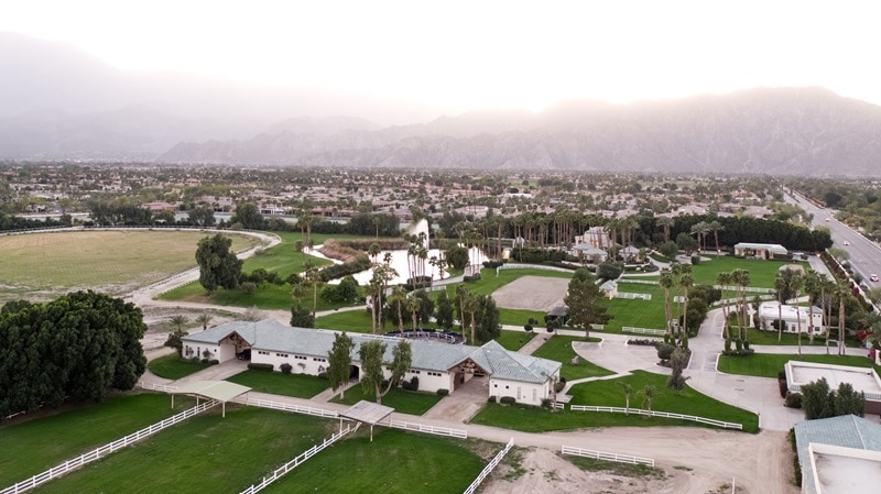 aerial view of the property showing the stables, gatehouse, the lake, and other structures on the property