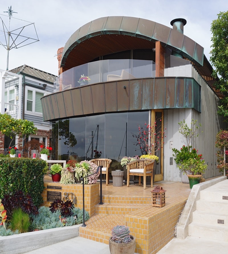 The Balboa Islan Jaws House in Newport Beach, CA, designed by architech John Lautner in 1980. It has a rounded metal top with glass walls across the facade.