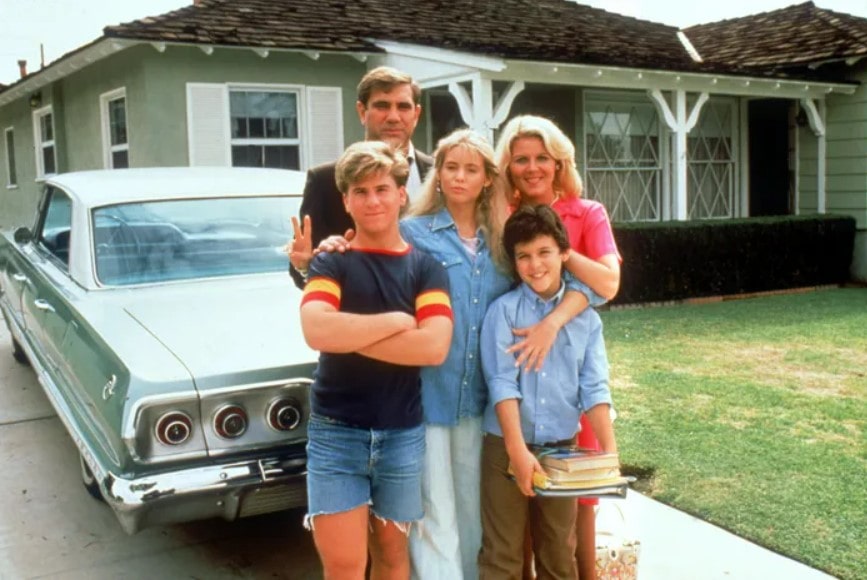 The Arnold house in "The Wonder Years", with the Arnolds standing in front, on the driveway, with the car visible behind them.