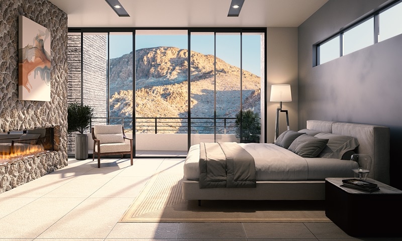 luxury bedroom with burning fireplace, a king-size bed, and large windows showing a mountain in the backdrop.