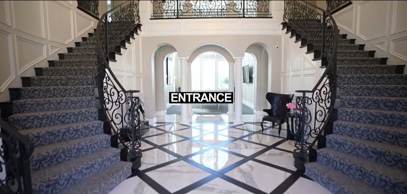 ultra-luxurious double grand staircase with carpeted stairs and wrought iron railings