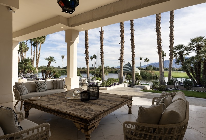 patio with large wooden table and seating overlooking the lake