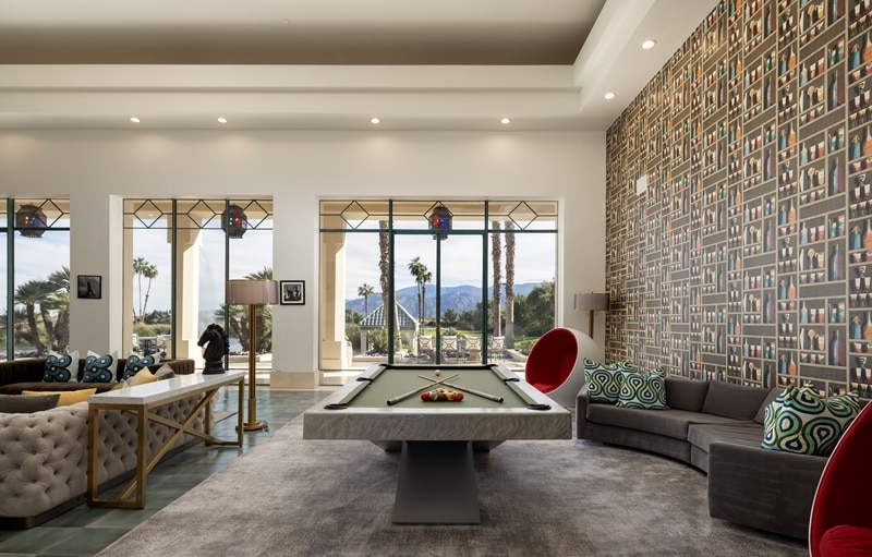 pool table with marble edges set next to a statement wall with floor-to-ceiling windows in the background