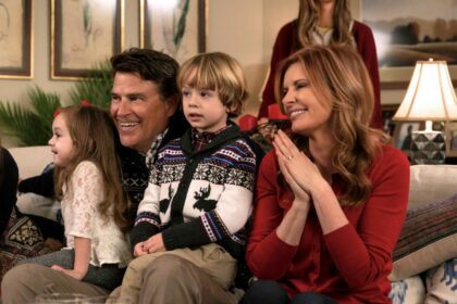 The Baxter family seen here smiling while sitting on a couch holding grandkids in a scene from The Baxters filmed inside the house