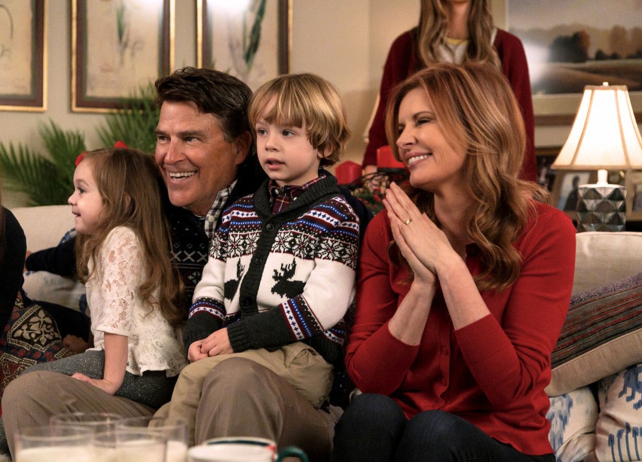 The Baxter family seen here smiling while sitting on a couch holding grandkids in a scene from The Baxters filmed inside the house