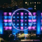 The new apartment building from The Circle, a 6-story residential building with blue and pink lights and a large circle on the facade.