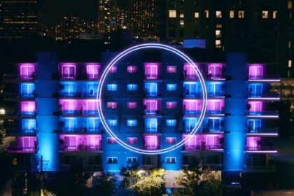 The new apartment building from The Circle, a 6-story residential building with blue and pink lights and a large circle on the facade.