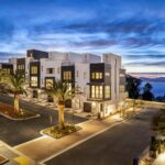 Modern two-story townhomes on Yerba Buena Island, with white and black exteriors, seen at twilight.