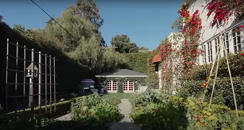 vegetable garden with a vine-covered guest house in the back
