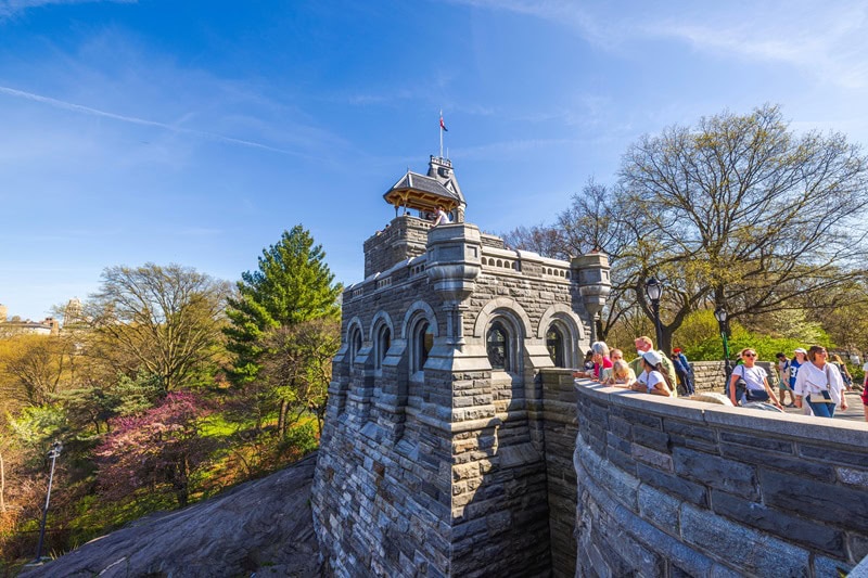 look-out tower in New York City's Central Park, with tourists leaning over the side to take in the views. 