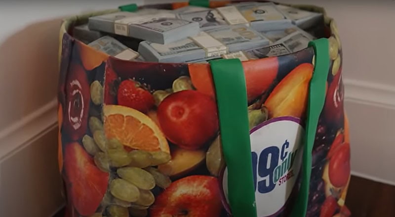 wooden sculpture that resembles a colorful grocery story bag full of money