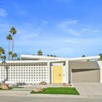 Architecturally distinct house in Palm Springs with a curvilinear design and a bright, yellow door.