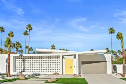 Architecturally distinct house in Palm Springs with a curvilinear design and a bright, yellow door.