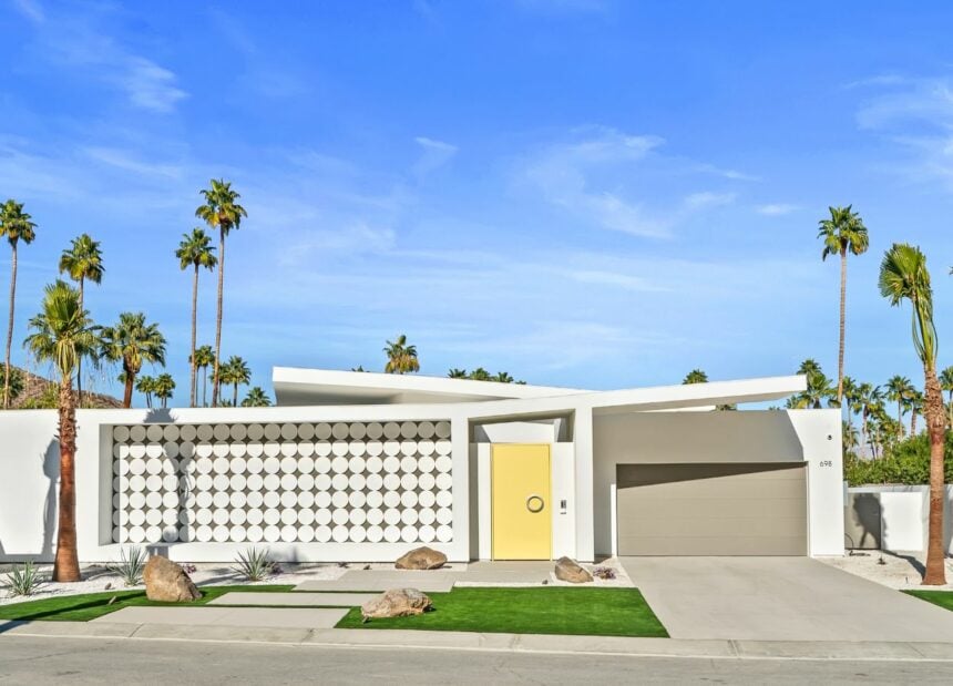 Architecturally distinct house in Palm Springs with a curvilinear design and a bright, yellow door.
