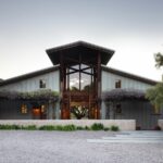 A rustic modern house built like a converted barn. Seen at twilight.