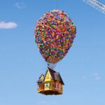 Airbnb recreation of the UP movie house, with 8,000 colorful balloons tied to it and held up in the air by a large crane