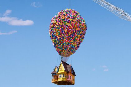 Airbnb recreation of the UP movie house, with 8,000 colorful balloons tied to it and held up in the air by a large crane