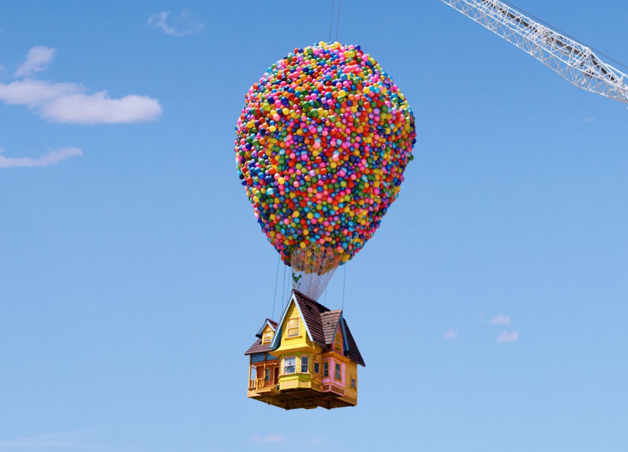 Airbnb recreation of the UP movie house, with 8,000 colorful balloons tied to it and held up in the air by a large crane